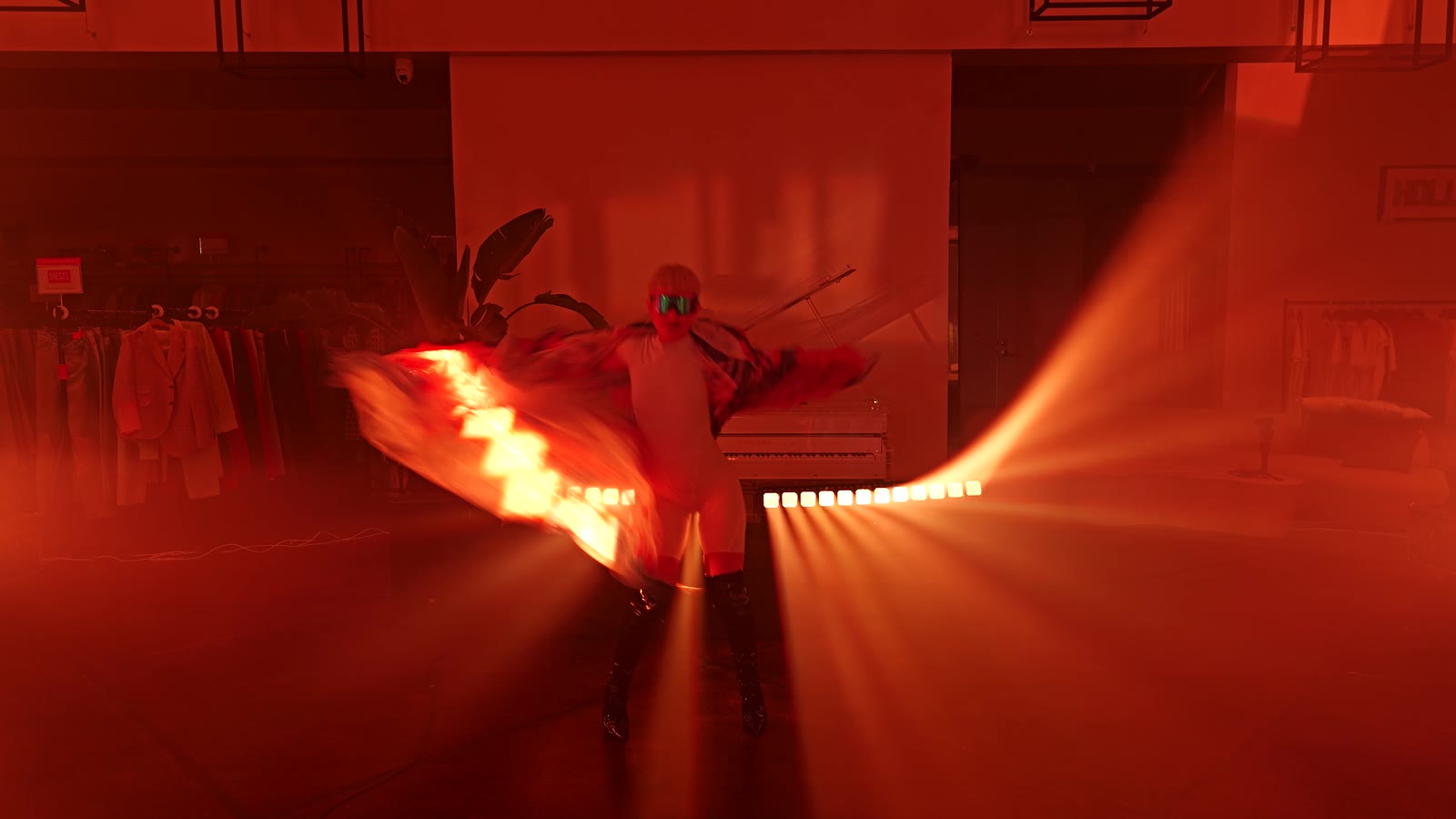 Night Pulse performer in a boutique lit by moving beams and a white grand piano